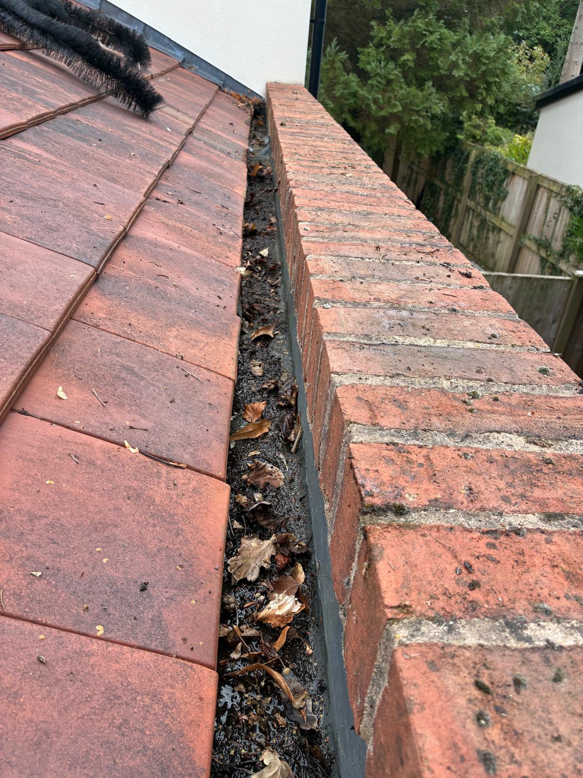 Gutter before cleaning during a gutter cleaning job in Woodford Stockport